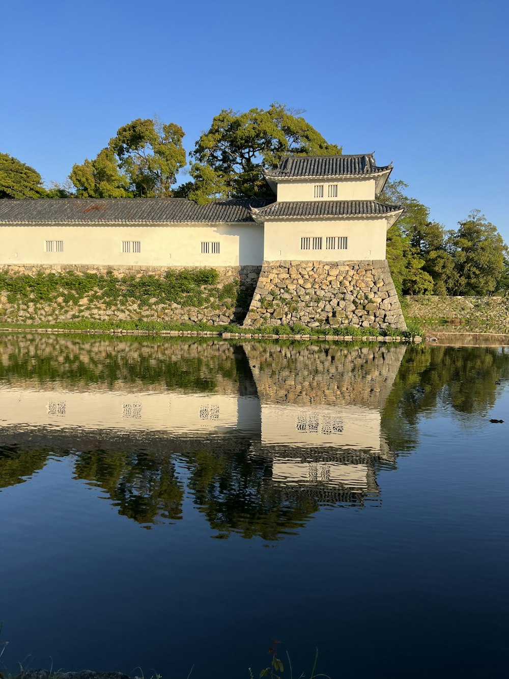 a building on a hill by a body of water