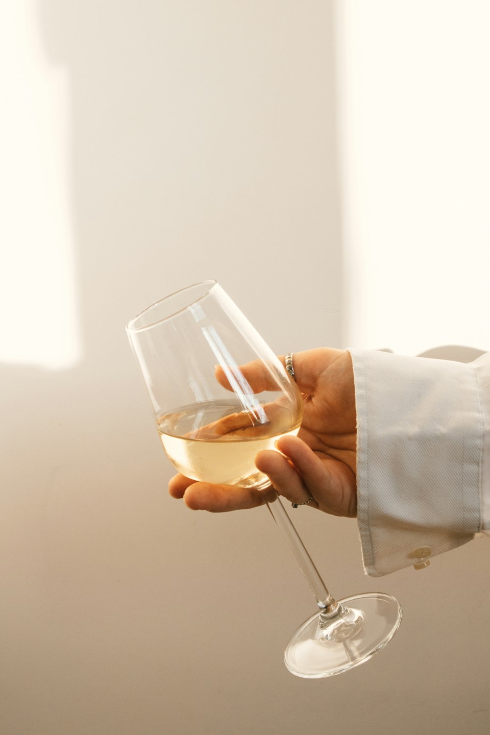 a hand holding a glass of liquid