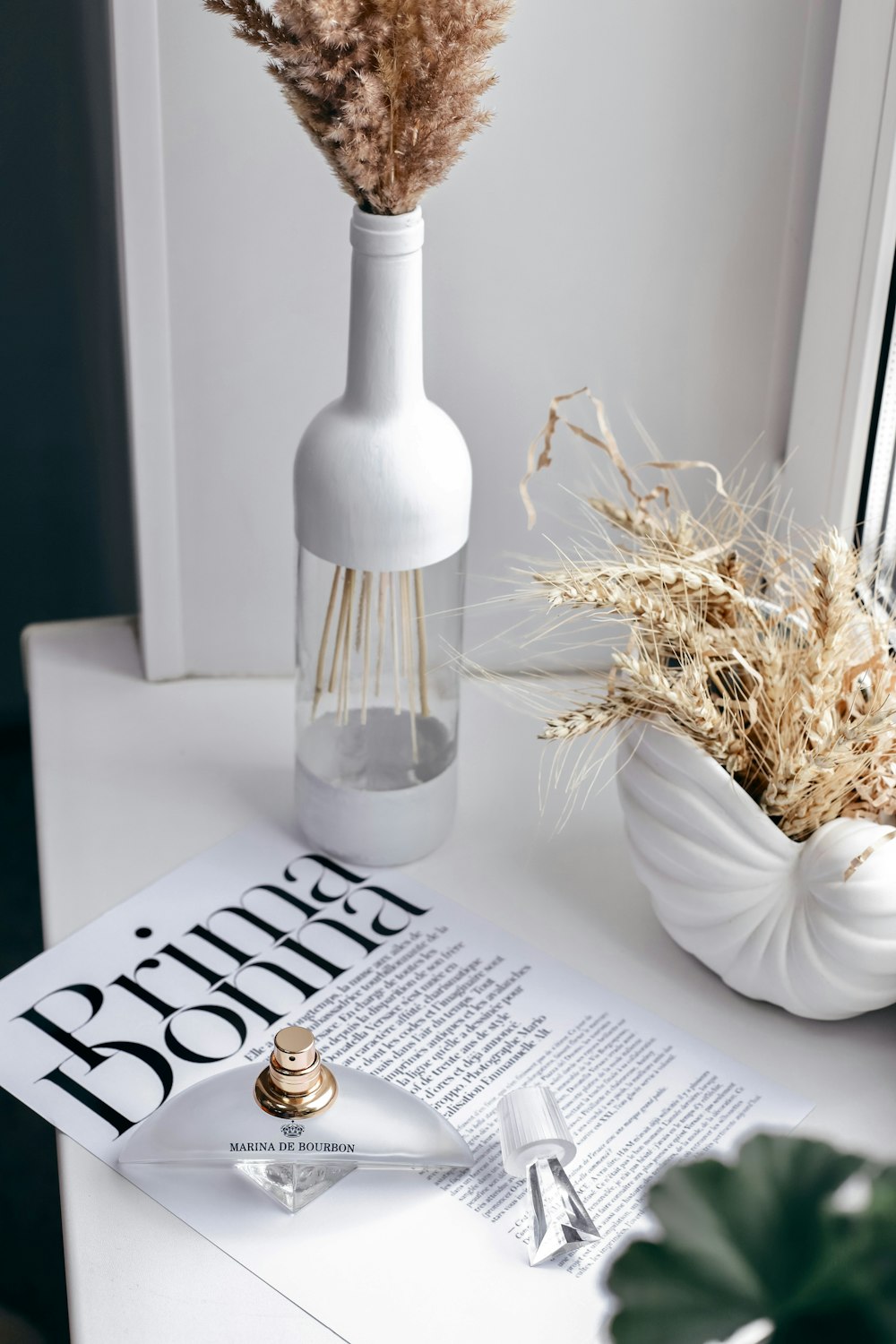 a vase with a candle and a glass bottle on a table