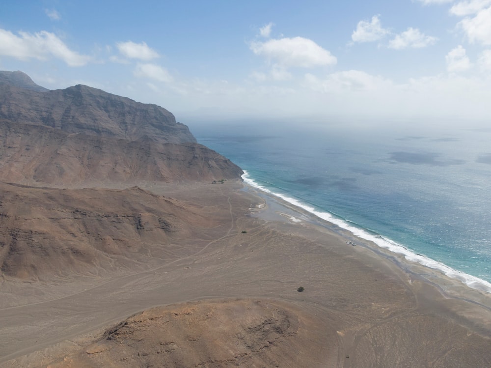 a sandy beach with a body of water in the background