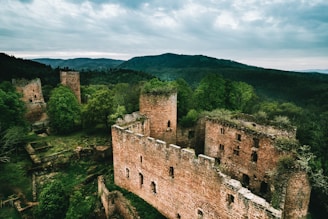 a stone building with a hill in the background