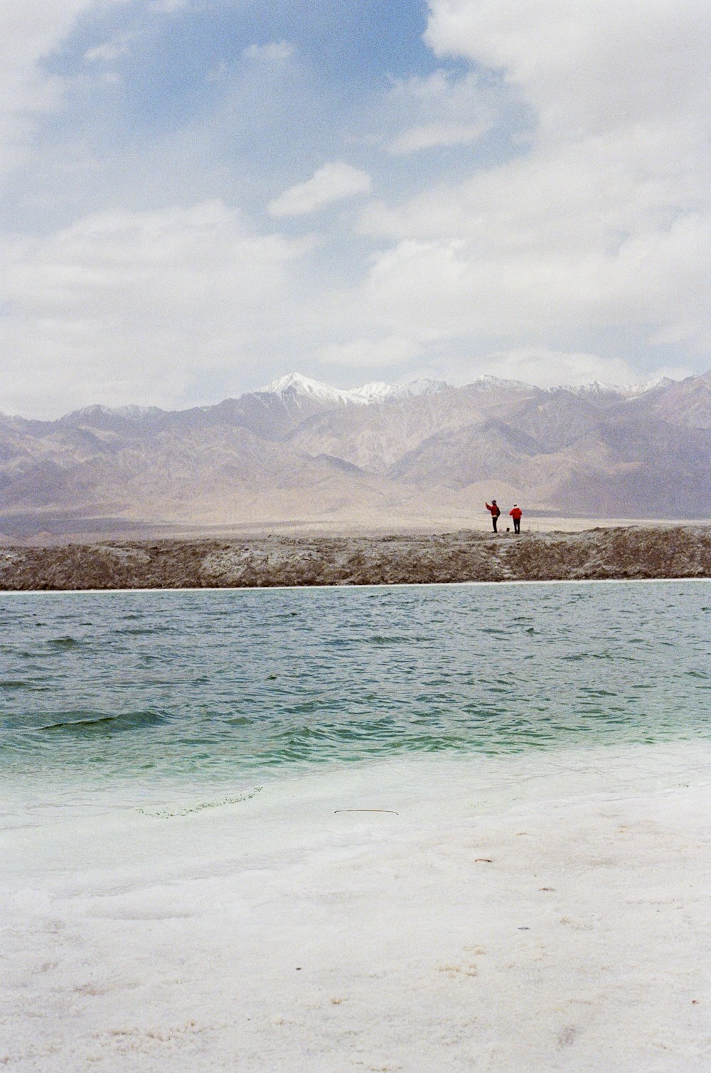 two people standing on a beach