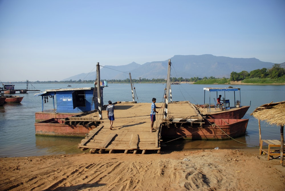 a group of boats sit on the shore of a lake