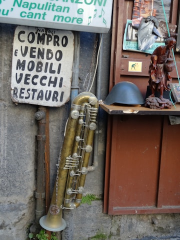 A vintage microphone and a signed guitar from Little Tony's collection displayed on a wooden table.