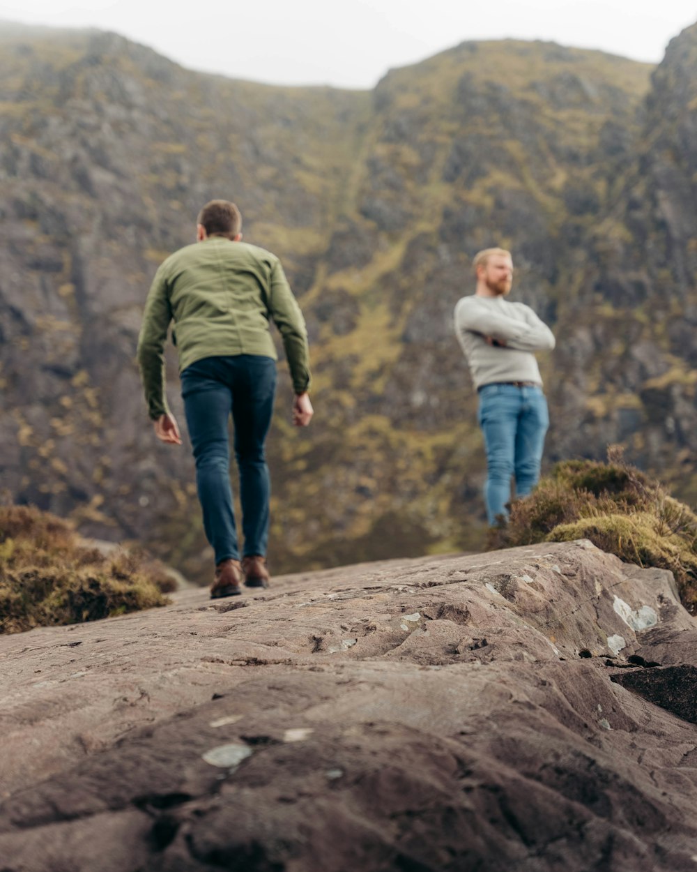 a man and woman walking on a rocky hill