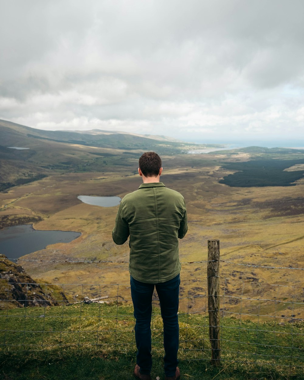 a man standing on a hill overlooking a valley