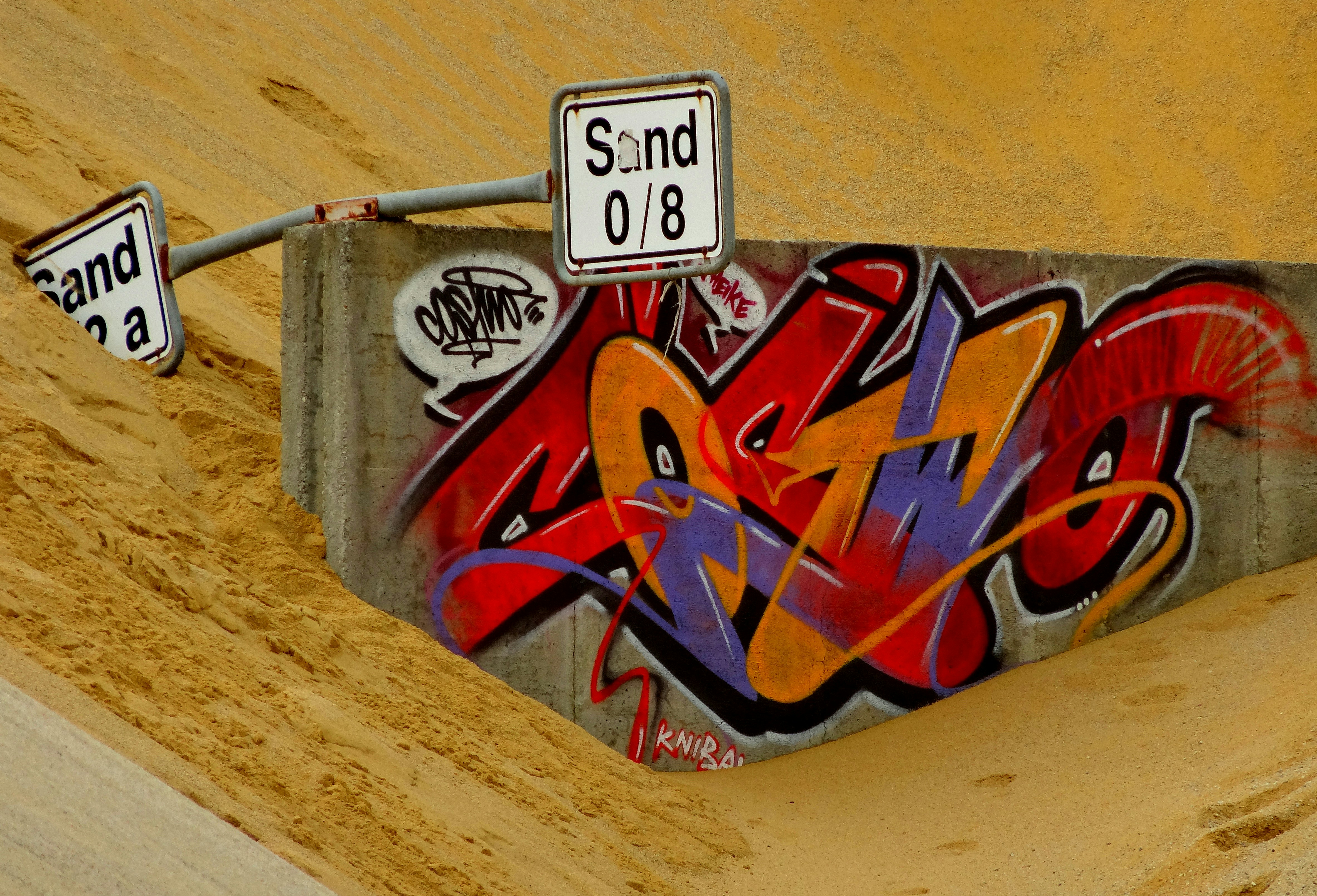 a red and white sign on a wooden surface
