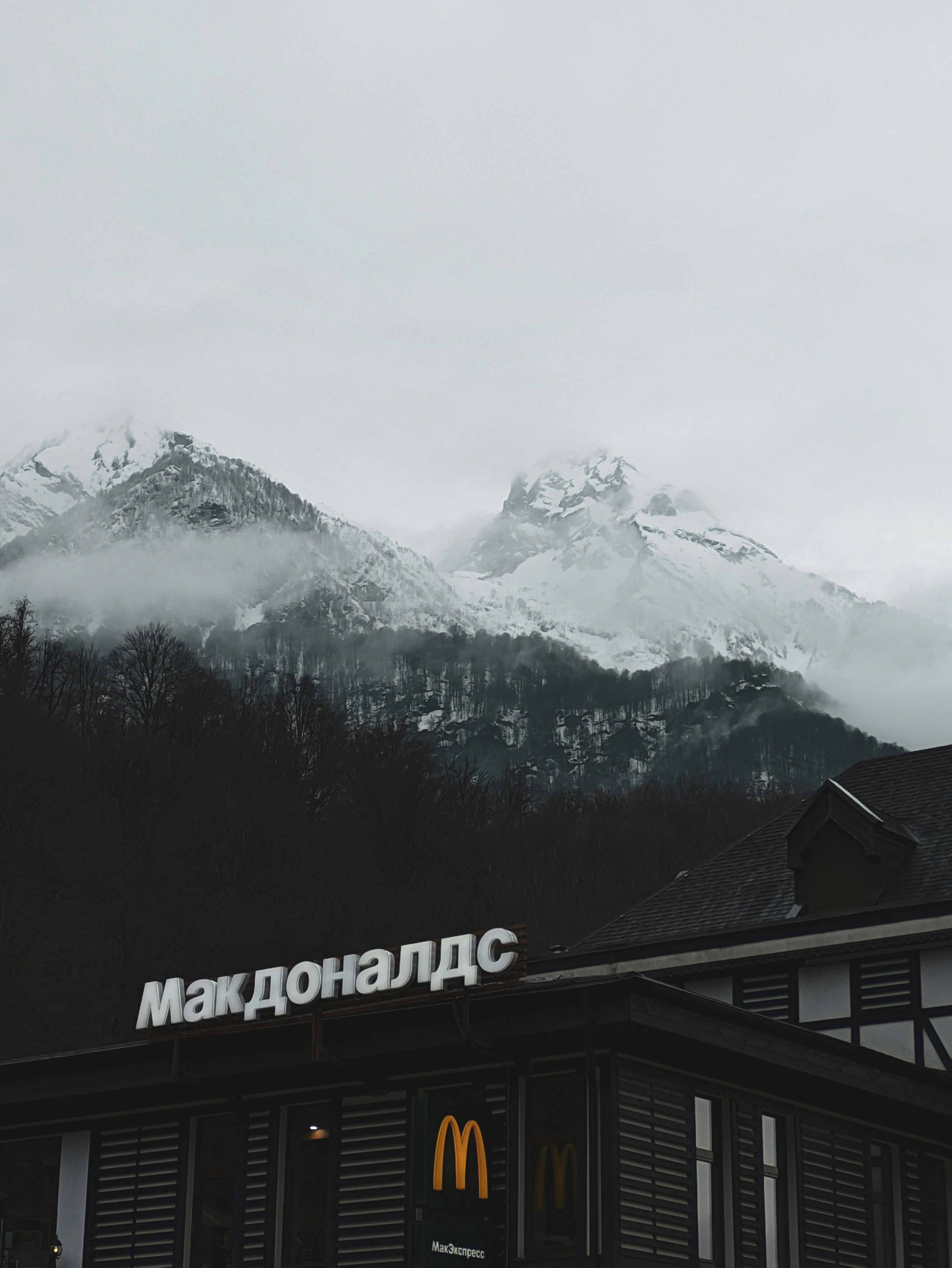 a building with a snowy mountain in the background