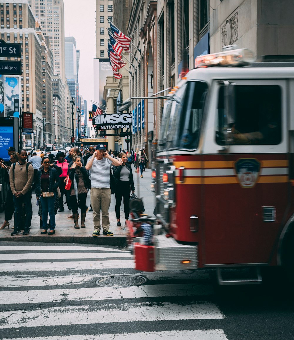 a group of people standing on the sidewalk next to a fire hydrant