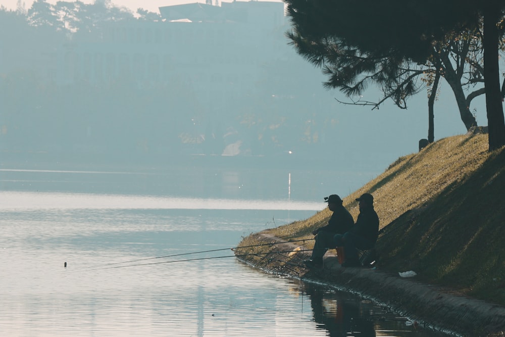 Un grupo de personas sentadas en una roca junto al agua