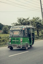 An e-rickshaw powered by lithium-ion batteries driving through an urban environment.