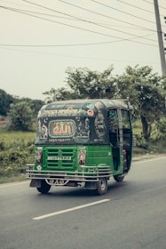 An e-rickshaw powered by lithium-ion batteries driving through an urban environment.