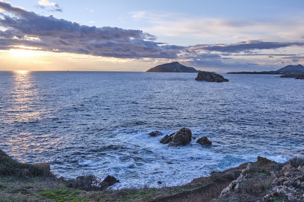 a body of water with rocks and land in the distance