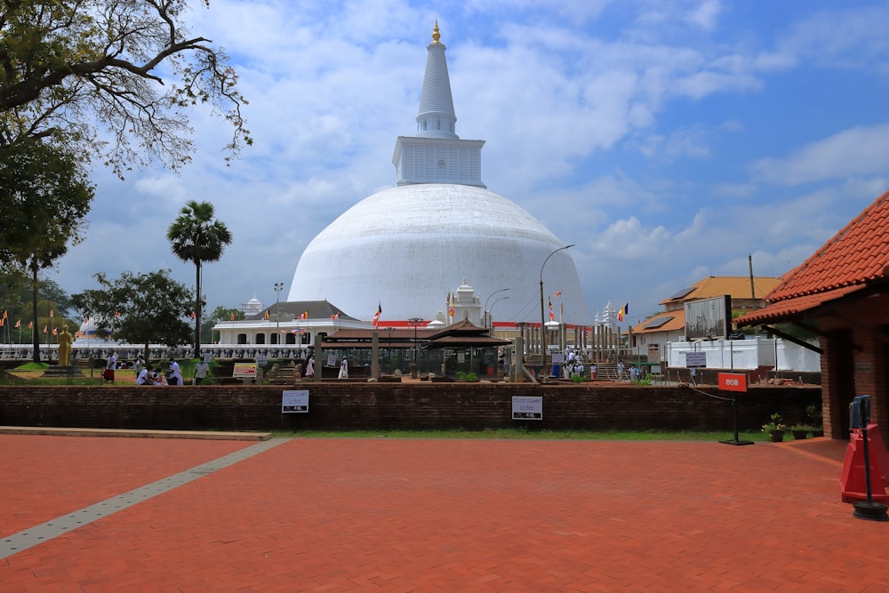 a large white building with a dome with Anuradhapura in the background