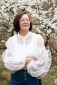 a woman standing in front of a flowering tree