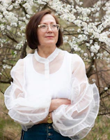 a woman standing in front of a flowering tree