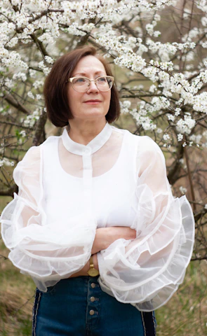 a woman standing in front of a flowering tree
