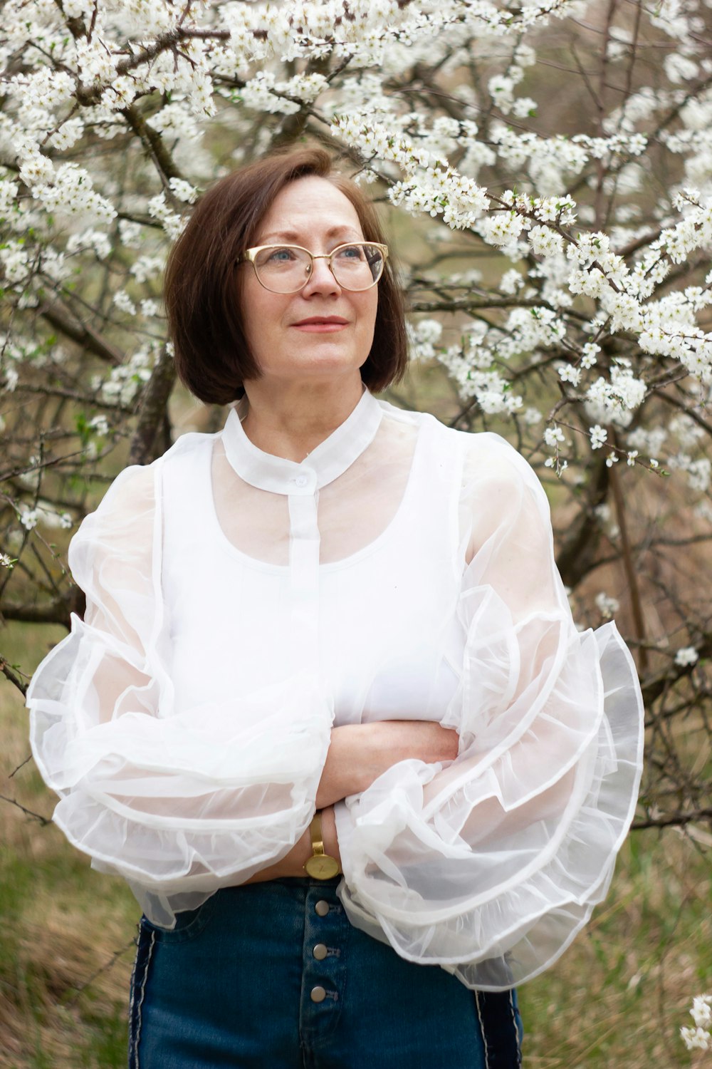 a woman standing in front of a flowering tree