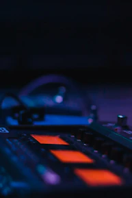 Close-up of sound mixing equipment with glowing orange highlights.
