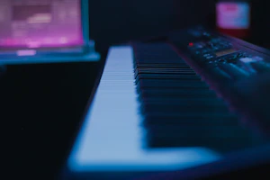 A modern digital keyboard with colorful backlit keys in a studio setting