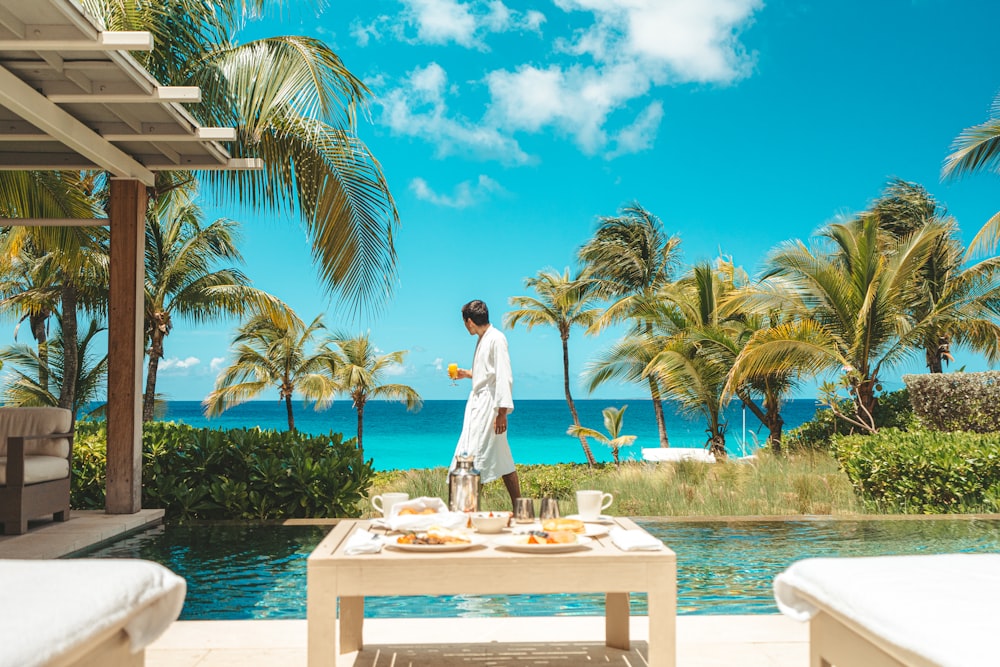 a person standing next to a table with food and drinks on it