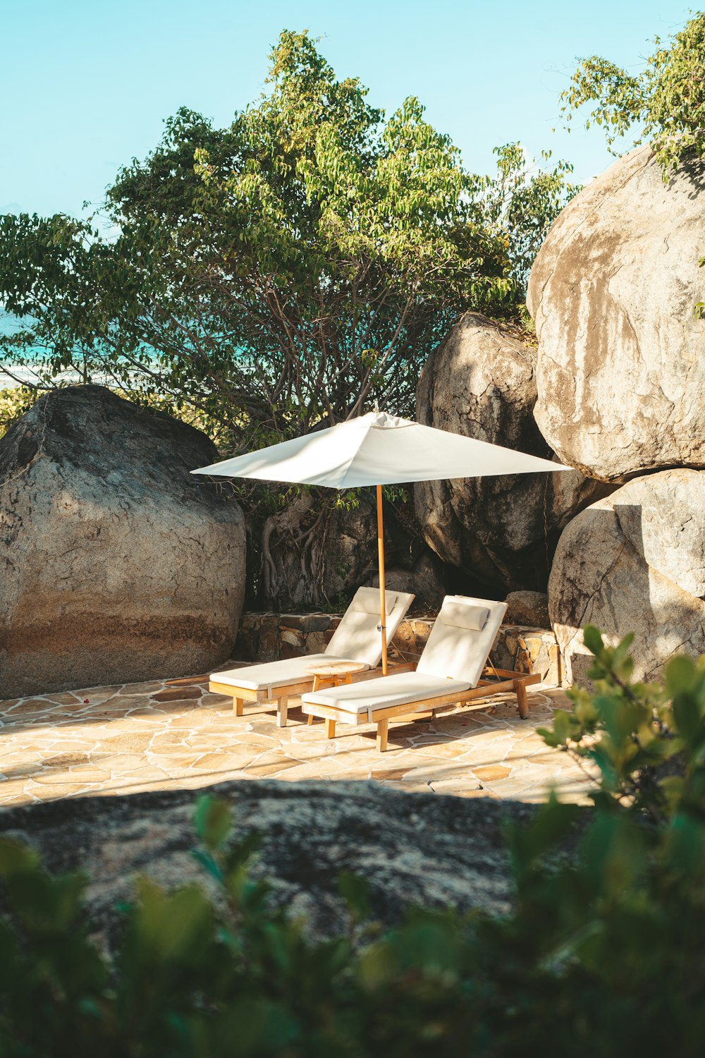 a couple of chairs and an umbrella on a patio