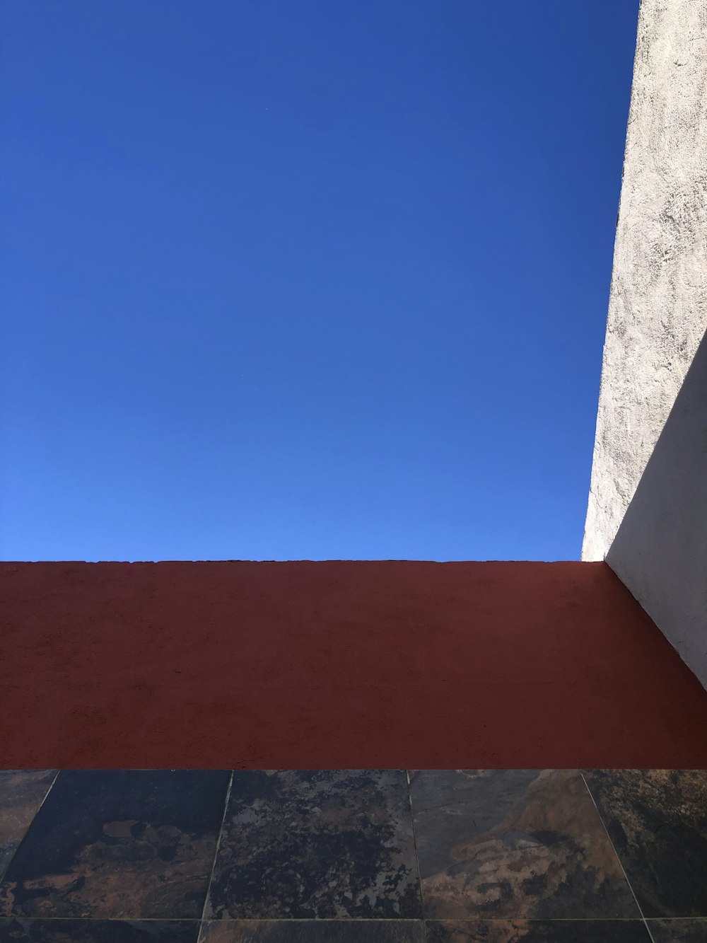 a red wall with a blue sky