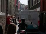 A delivery truck branded with newcorp asia b.v. logo navigating through a European city