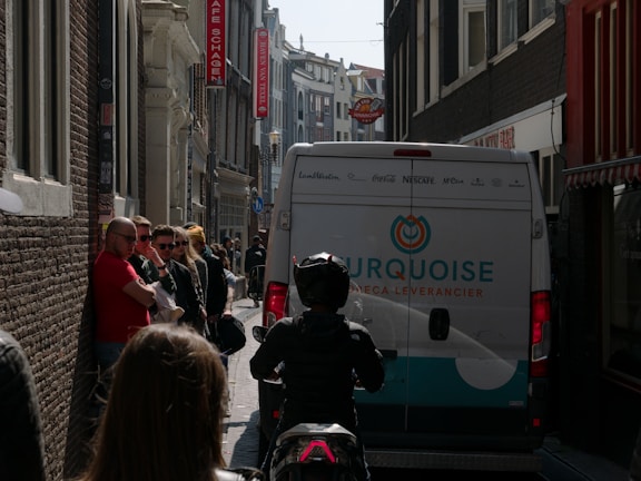 A delivery truck branded with newcorp asia b.v. logo navigating through a European city
