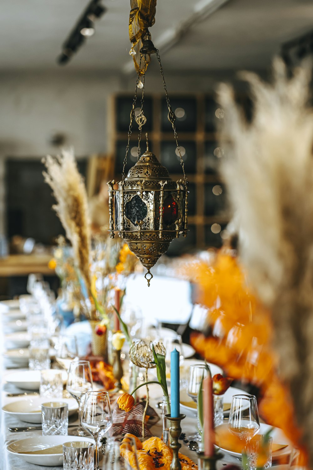 a table with a chandelier and many glasses and candles