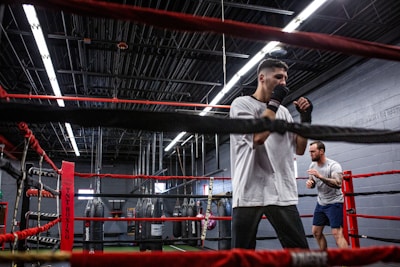 Veterans sparring in a well-lit boxing ring.