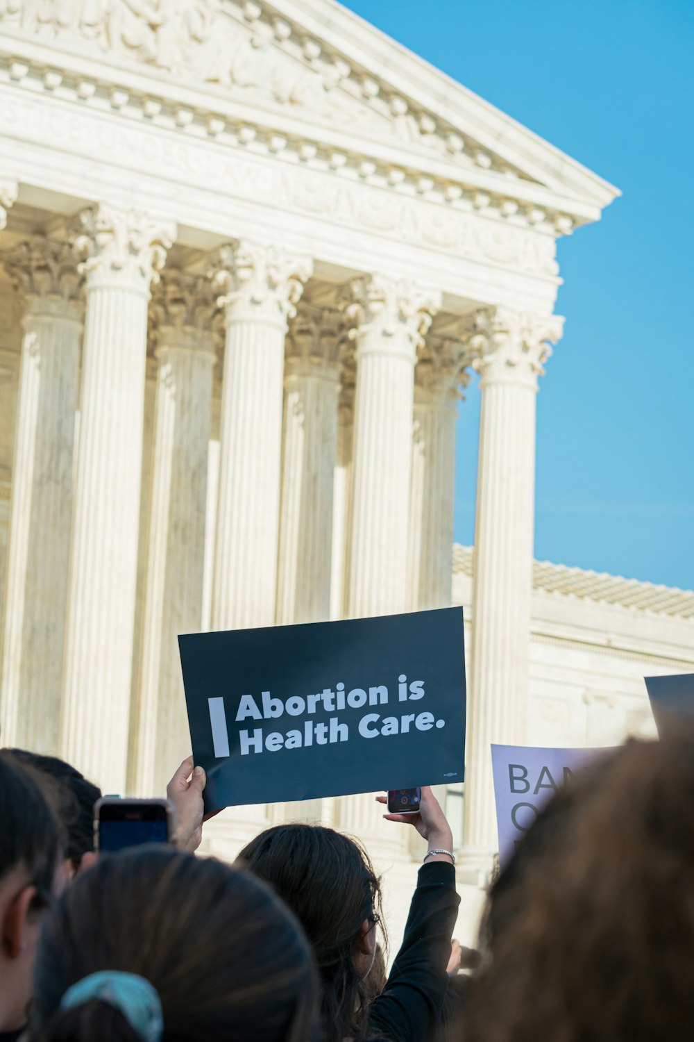 a group of people holding a sign in front of a building