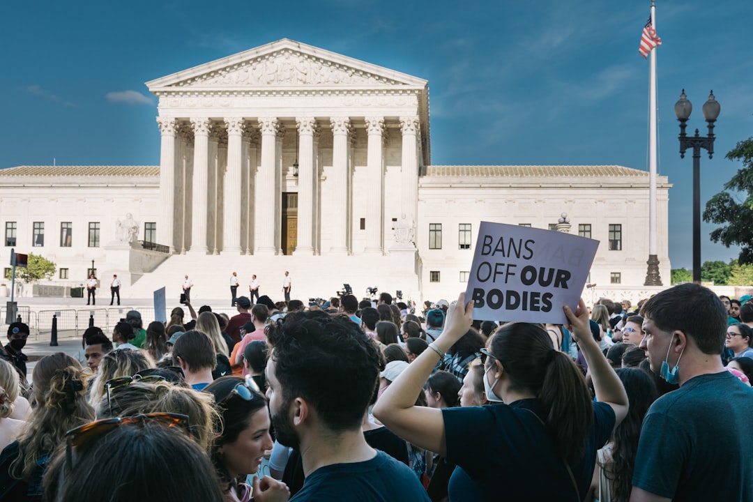 a group of people in front of a white building with columns, Bans Off Our Bodies.