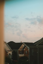 Team installing new asphalt shingles on a suburban home’s roof at sunset.