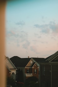Team installing new asphalt shingles on a suburban home’s roof at sunset.