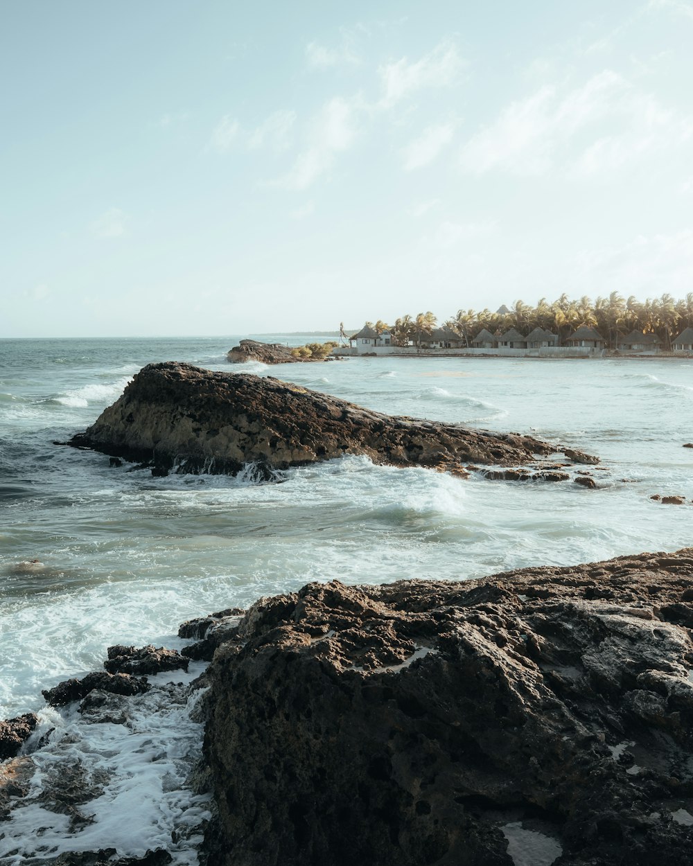 a rocky beach with a large body of water in the background