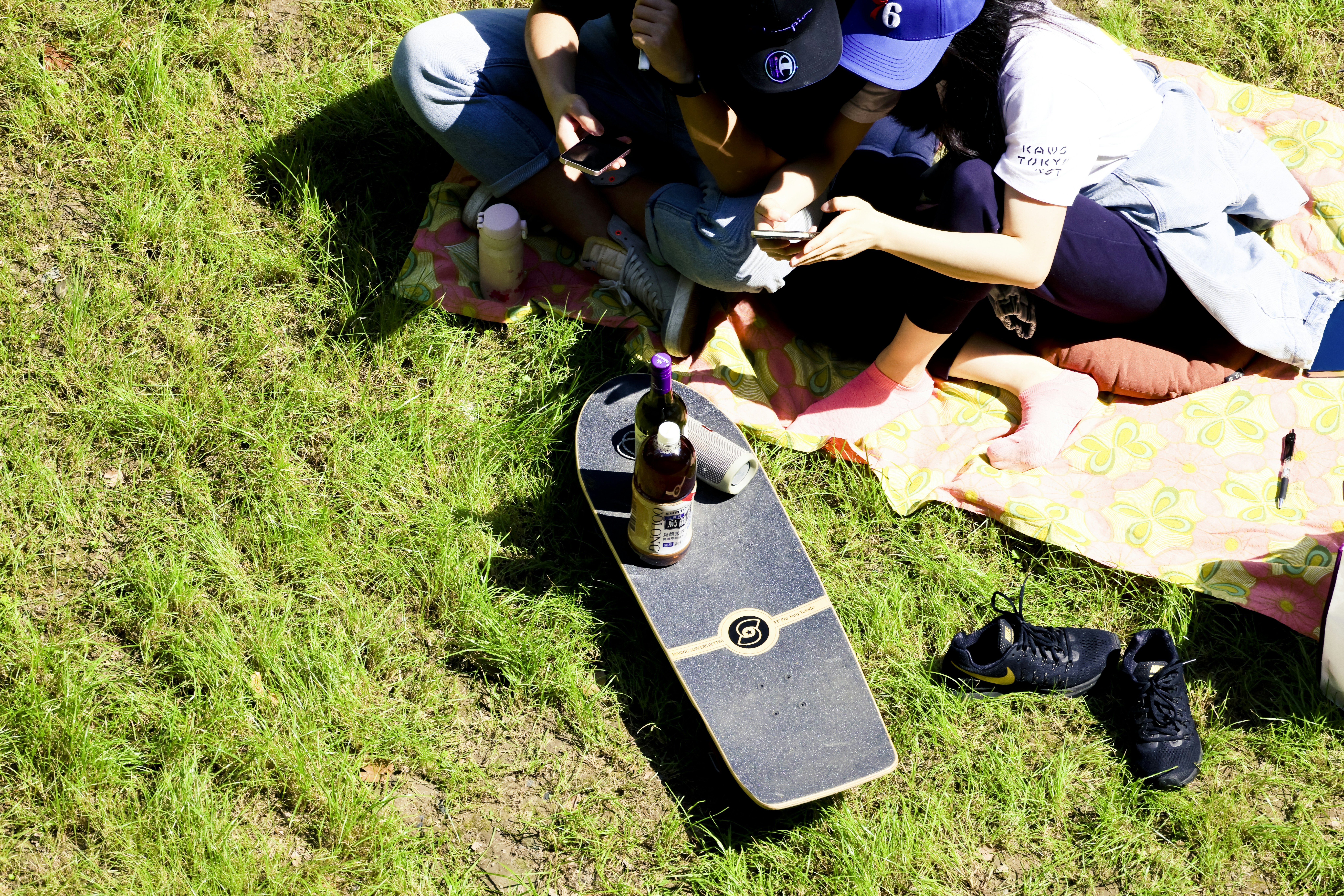 a group of people sitting on the grass with a skateboard