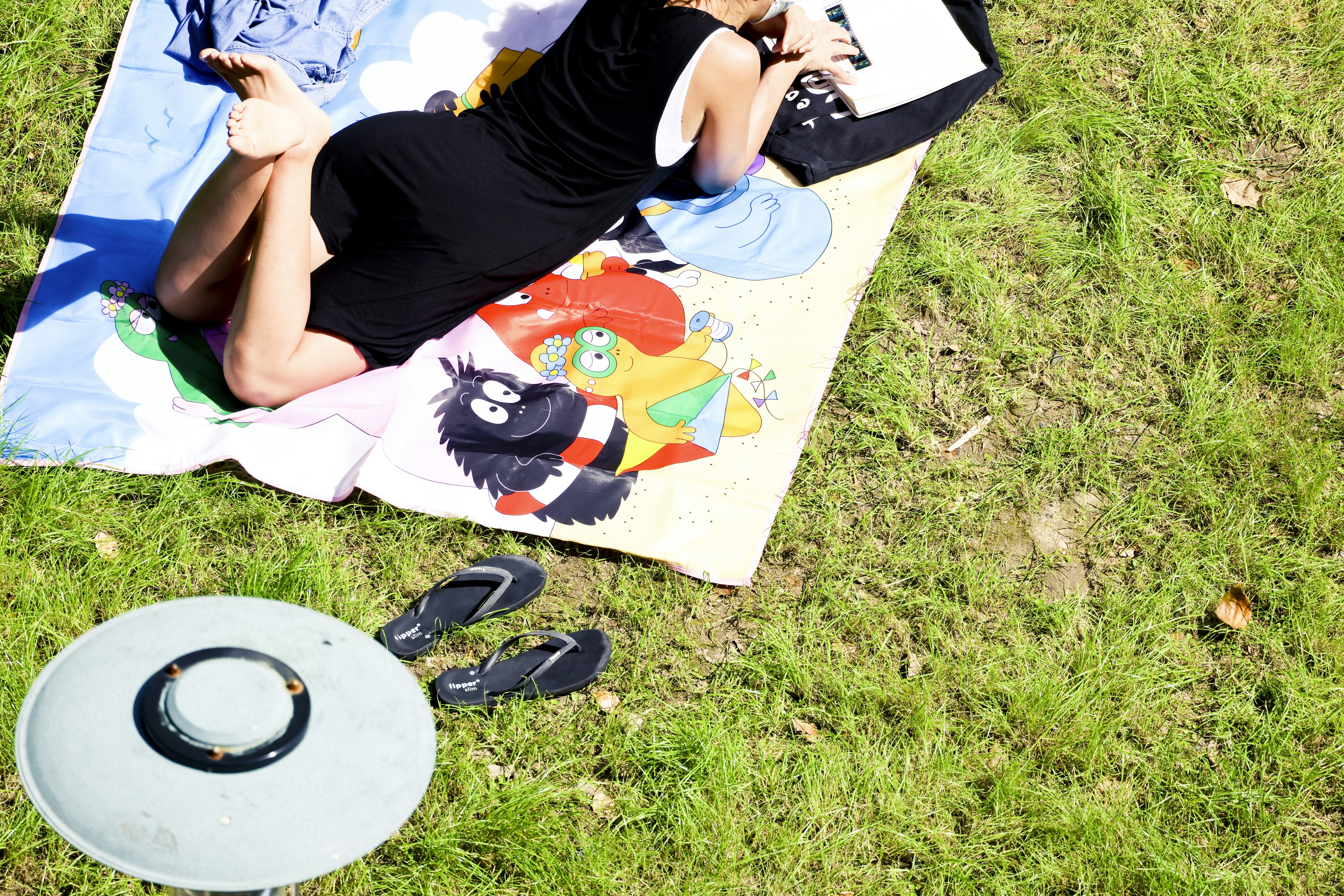 a person lying on a blanket on grass