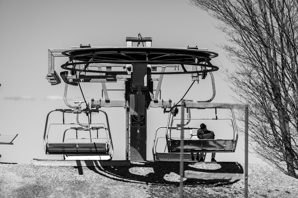 a person sitting on a chair on a ski lift