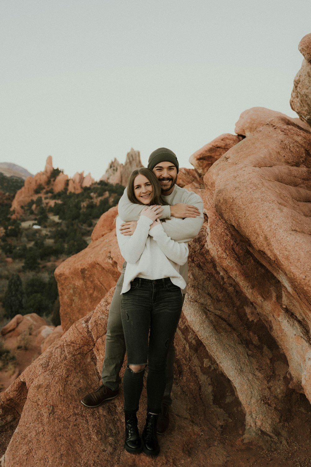 a man and woman posing for a picture on a rock cliff