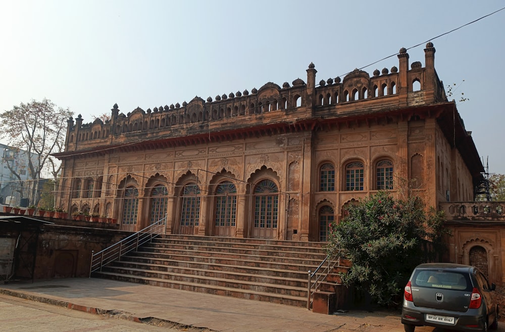 a building with stairs and a car parked in front of it