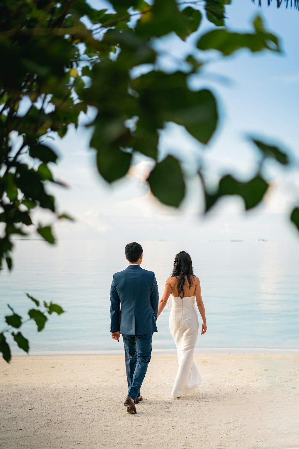 a man and woman walking on a beach