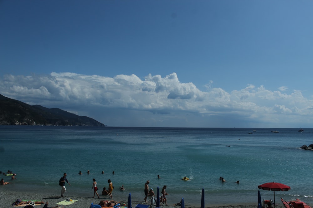 a beach with people and mountains in the background