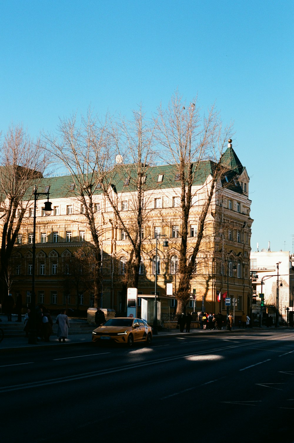 a street with a building on the side and trees on the side