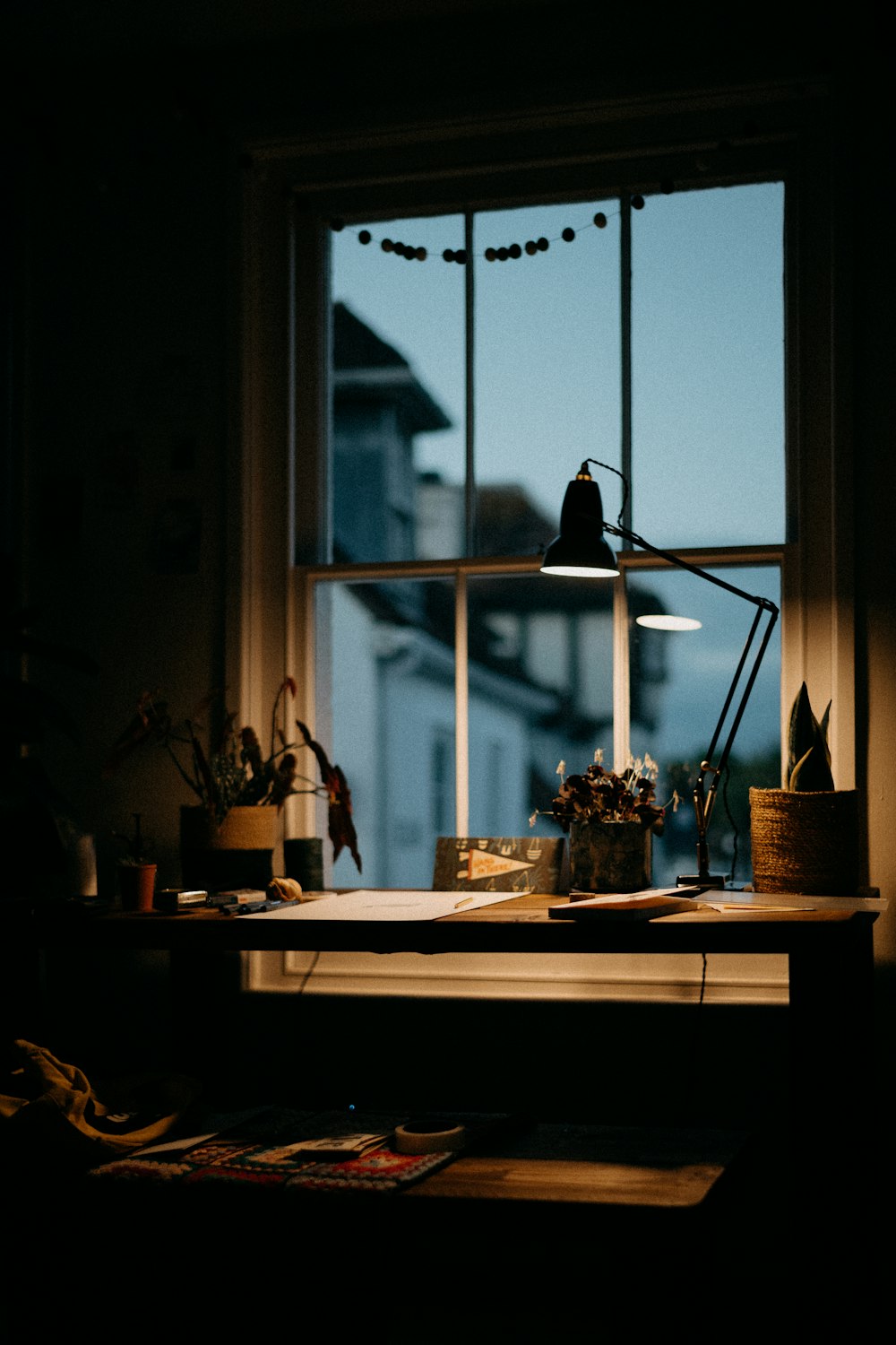 une fenêtre avec une lampe et une table avec des objets dessus