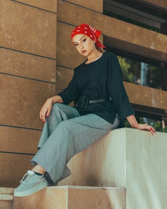 a person sitting on a ledge posing for the camera