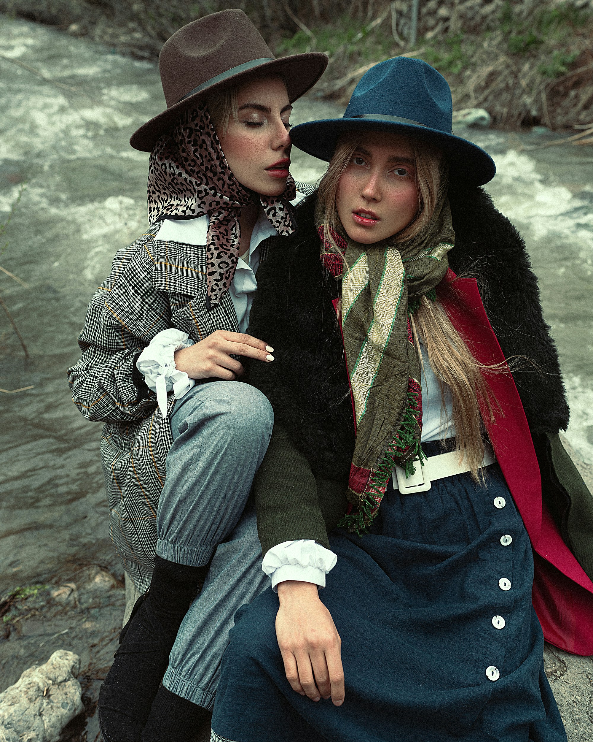 Ein paar Frauen mit Hüten sitzen auf einem Felsen