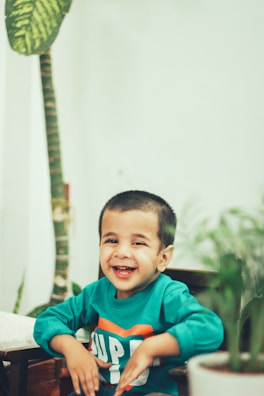 a child smiling with his hands together