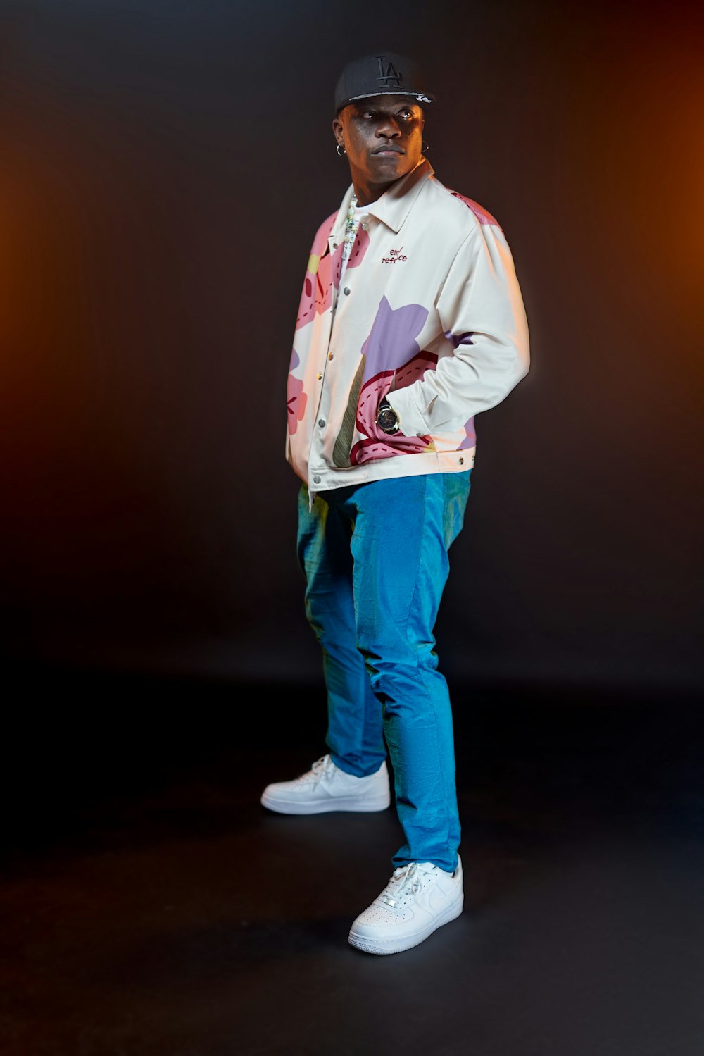 a man wearing a hat and a white shirt with a red and blue background