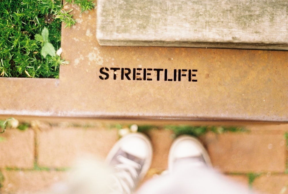 a pair of feet on a stone ledge with a sign